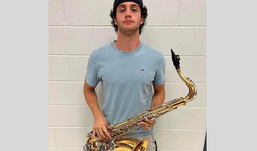 Student holding saxophone