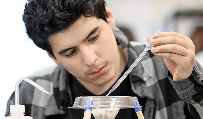 a student in science lab performing a lab experiment.